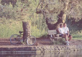 Couple sitting on a bench looking at the lake.