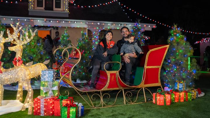 Family poses for photo on sled at Candlelight Walk at Heritage Hill Historical Park.