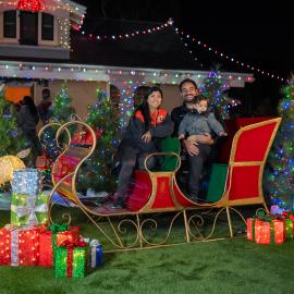 Family poses for photo on sled at Candlelight Walk at Heritage Hill Historical Park.