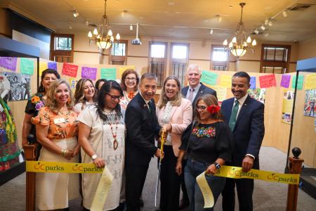 Group of city and county officials cut the ribbon to open a new art exhibit at the Old Orange County Courthouse.